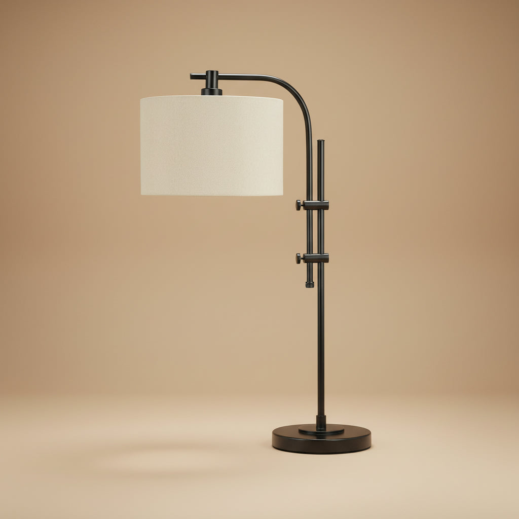 A modern adjustable table lamp with a matte black metal frame and a cylindrical off-white fabric shade, set against a warm beige studio background.