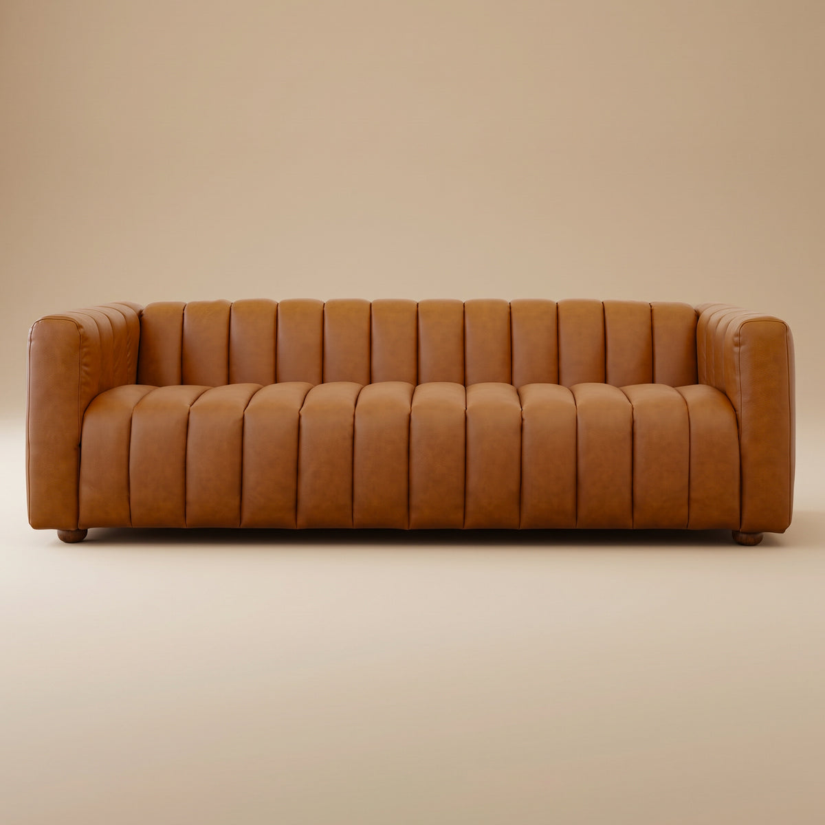 Cognac brown leather channel-tufted sofa with rounded arms and short wood legs on a plain beige studio background | MidinMod