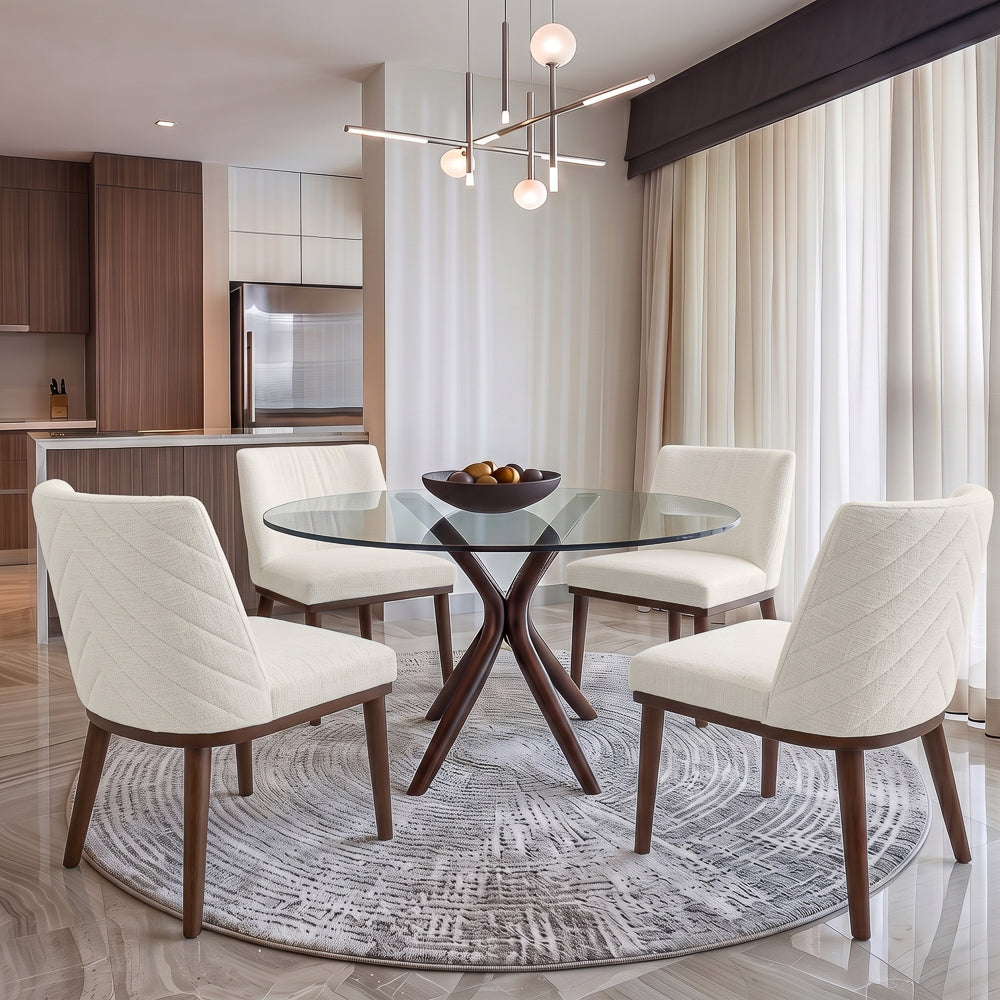 Four white dining chairs around a round glass table in a bright kitchen with a globe chandelier
