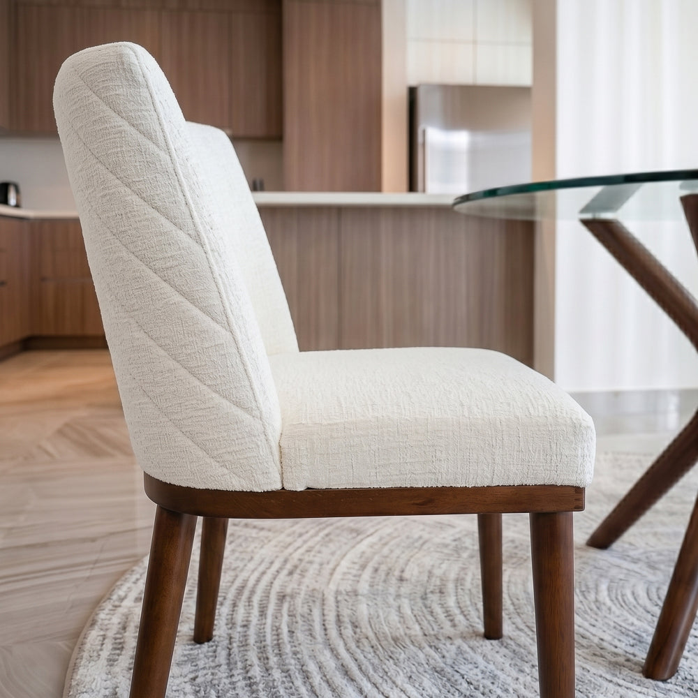 Side profile of the dining chair showing the chevron-stitched back panel and tapered legs