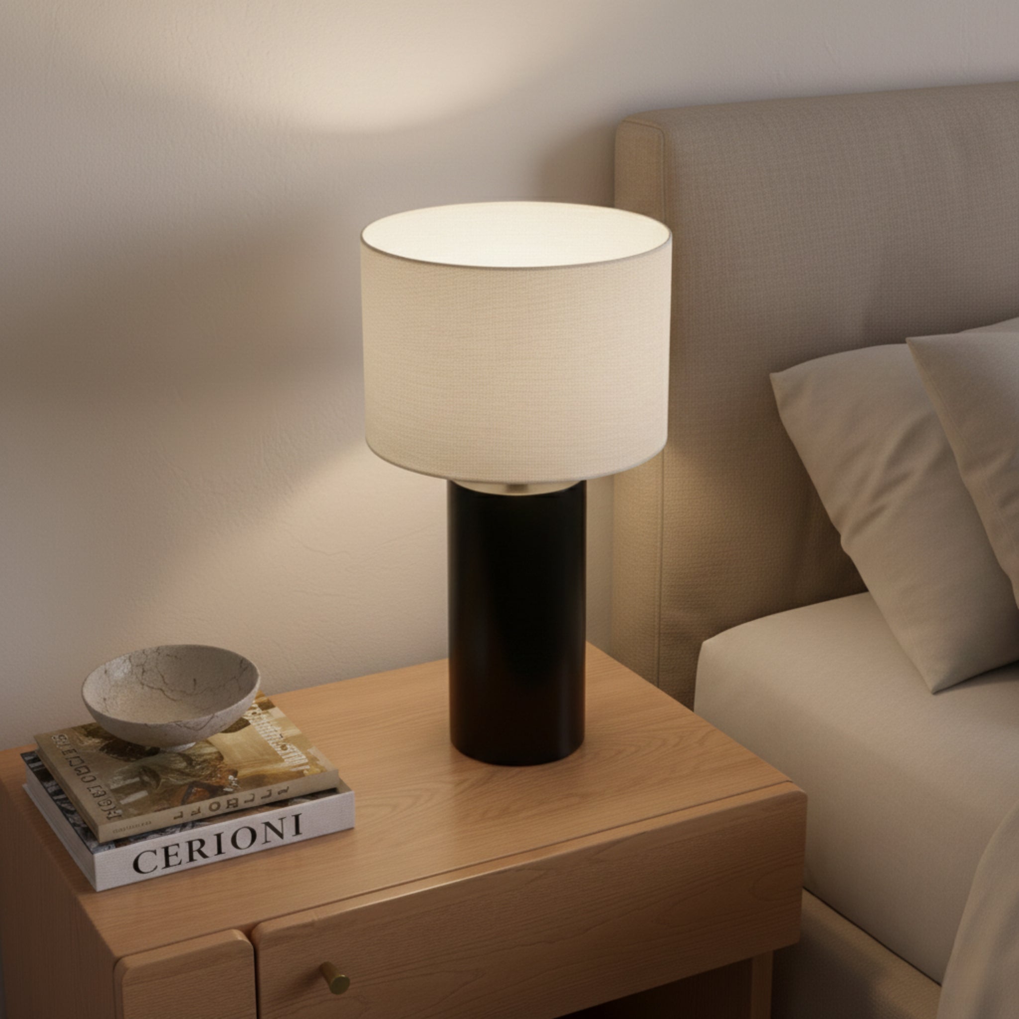 Illuminated Table Lamp on a nightstand with stacked books and a small bowl, warm evening light
