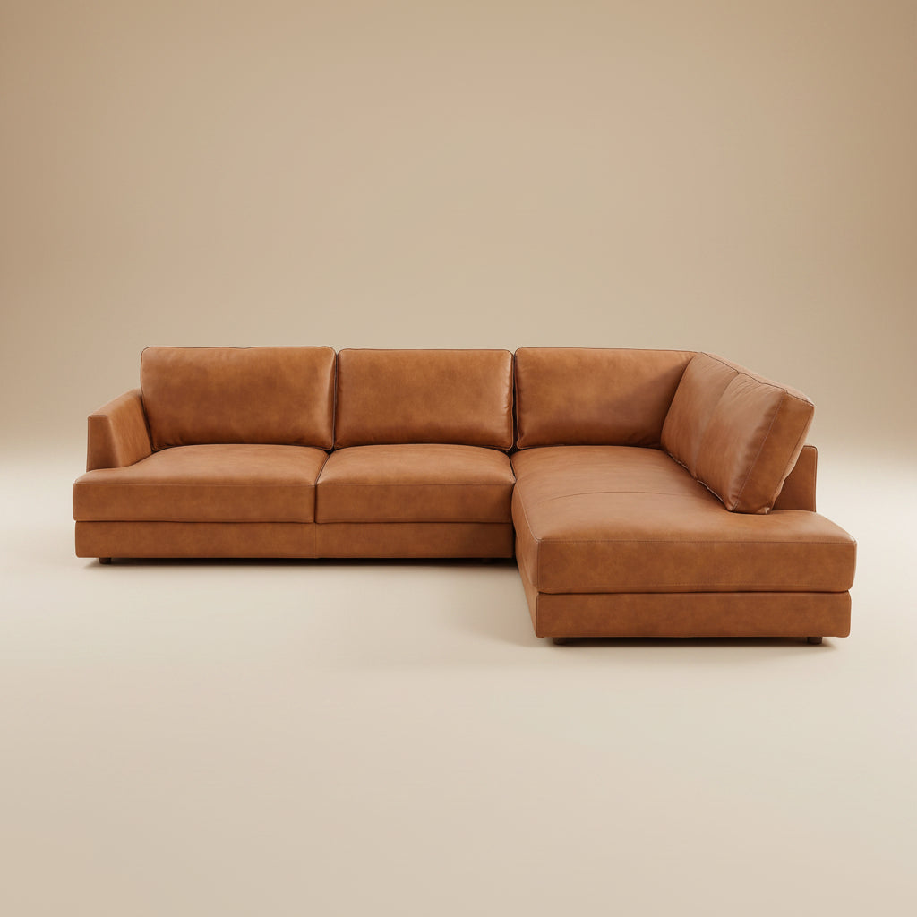 Tan leather right-facing sectional sofa on a plain beige studio backdrop, shown straight on