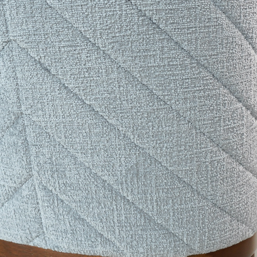 Extreme close-up of the woven grey upholstery and diagonal quilted stitching