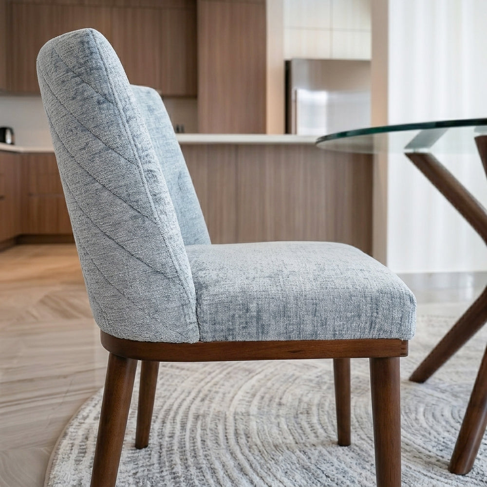 Side and rear view of a grey dining chair showing the curved diagonally stitched backrest