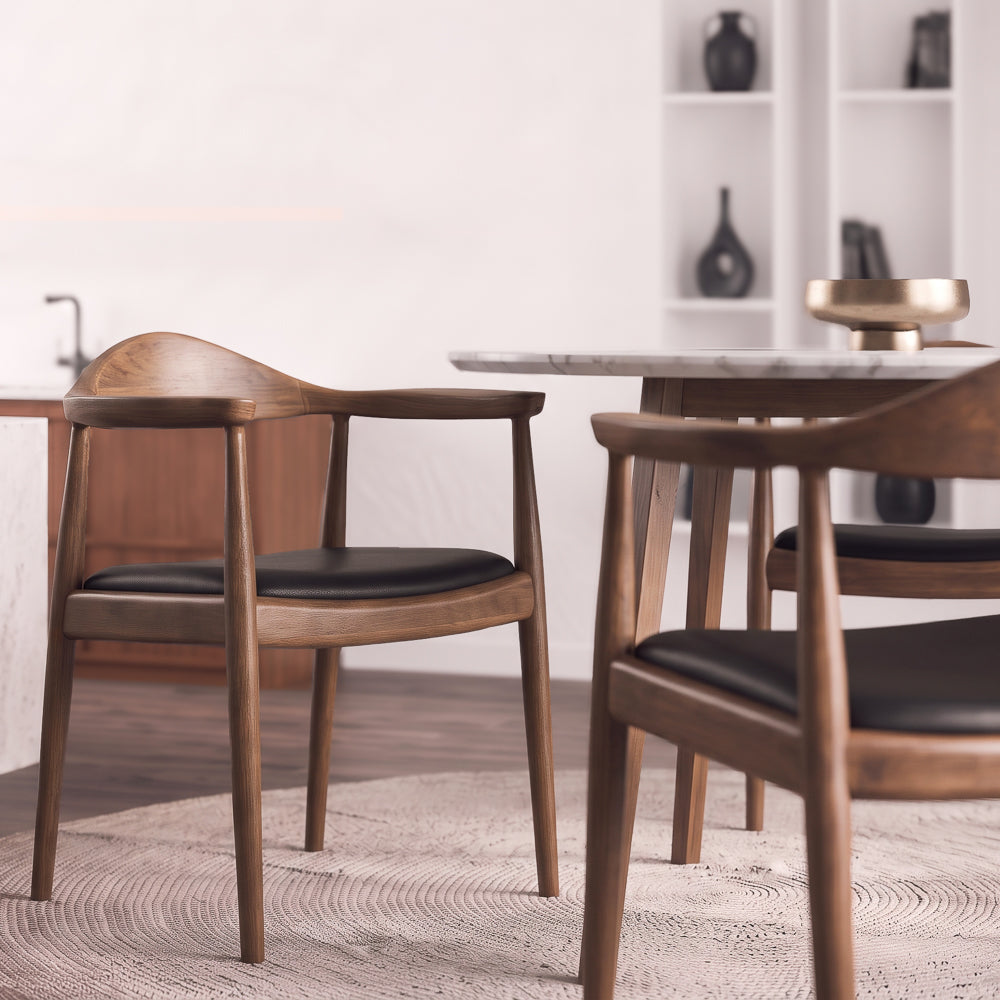 Freya chair at a marble dining table, second chair cropped in the foreground, gold bowl on the table