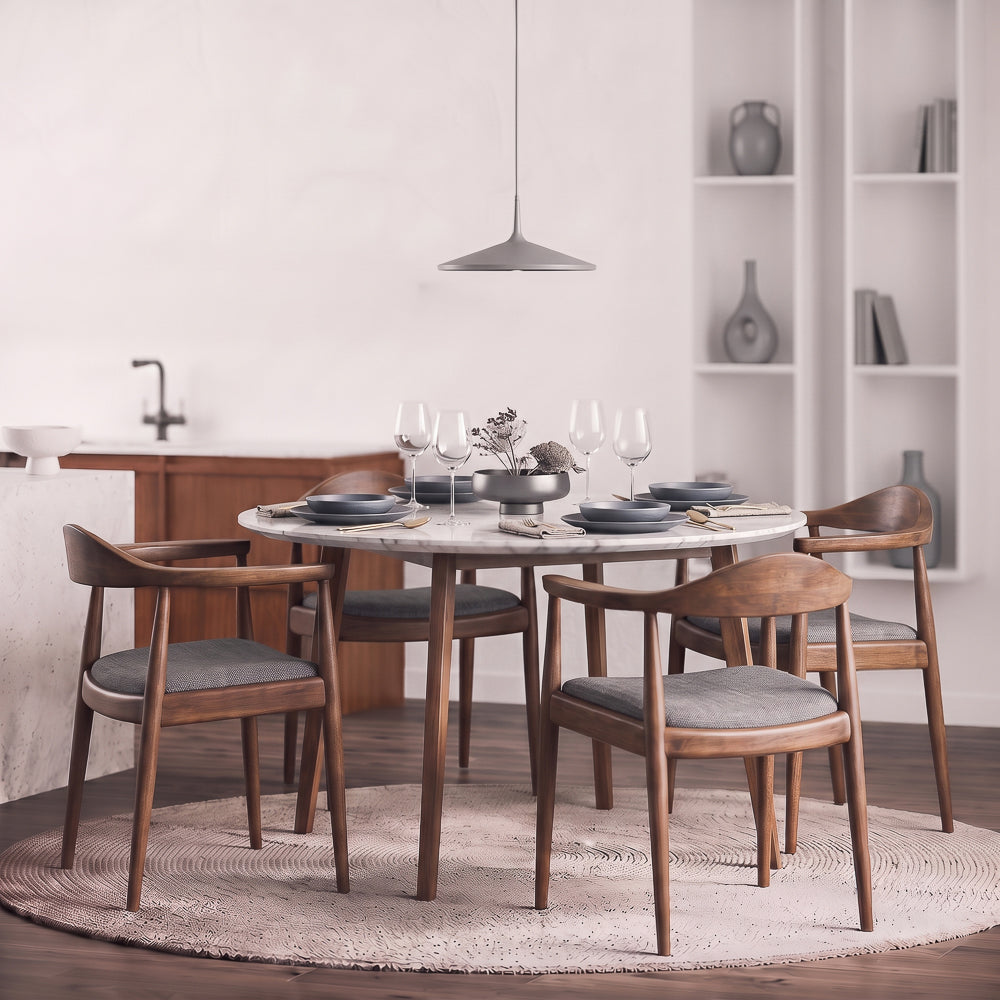 Four Freya grey-fabric dining chairs around a round marble table in a bright kitchen dining room.