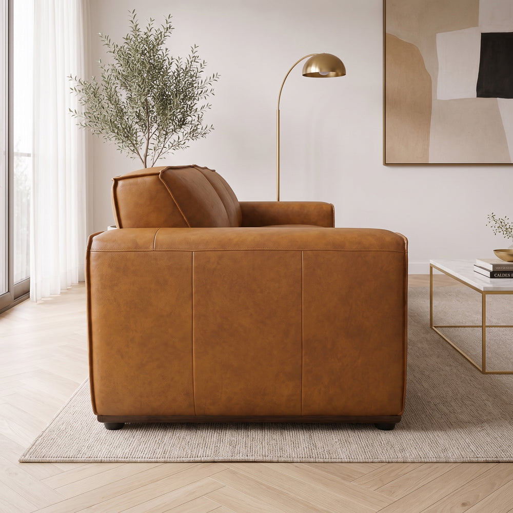 Rear view of the tan leather sofa showing the panelled back seams and low block feet