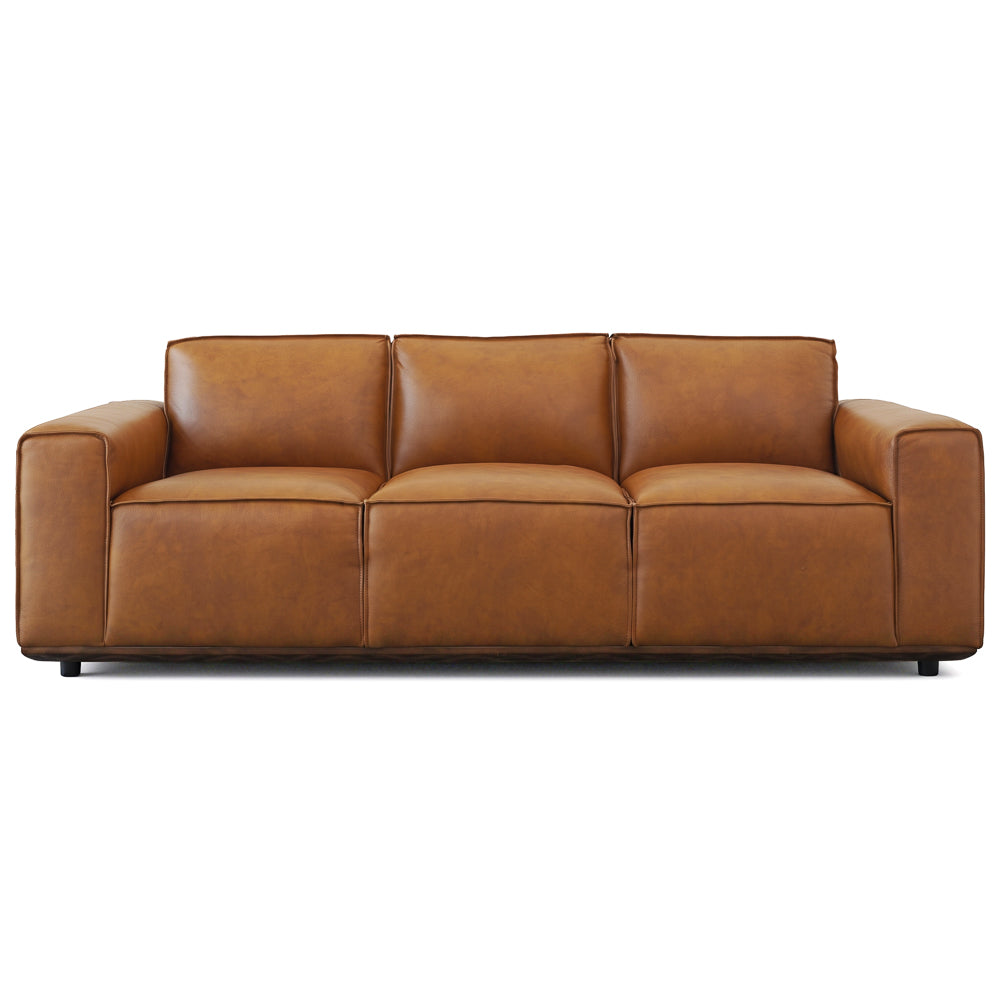Front-facing cutout of the tan leather sofa on white, three cushions above a dark base