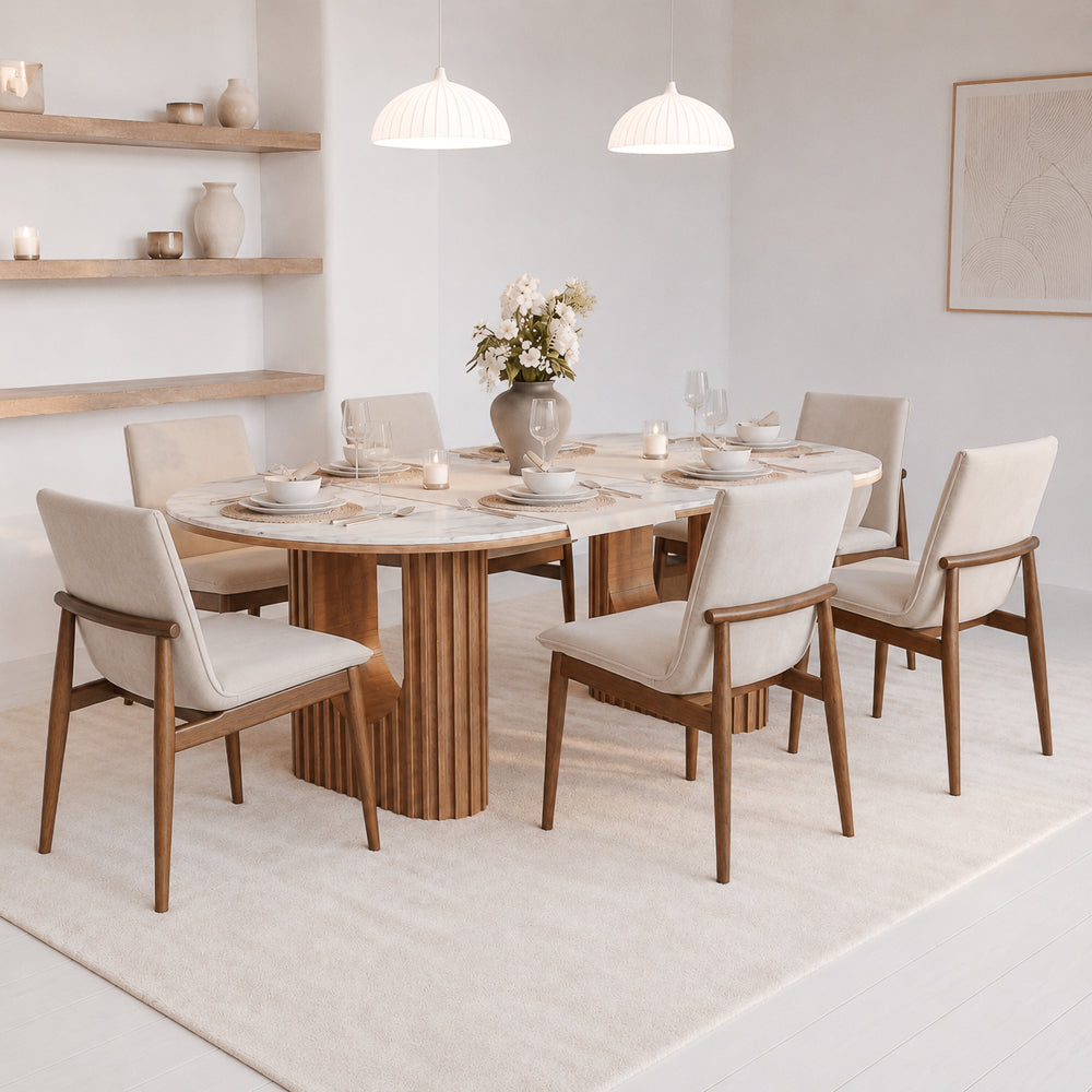 Six beige velvet dining chairs around an oval fluted-base table in a bright, airy dining room