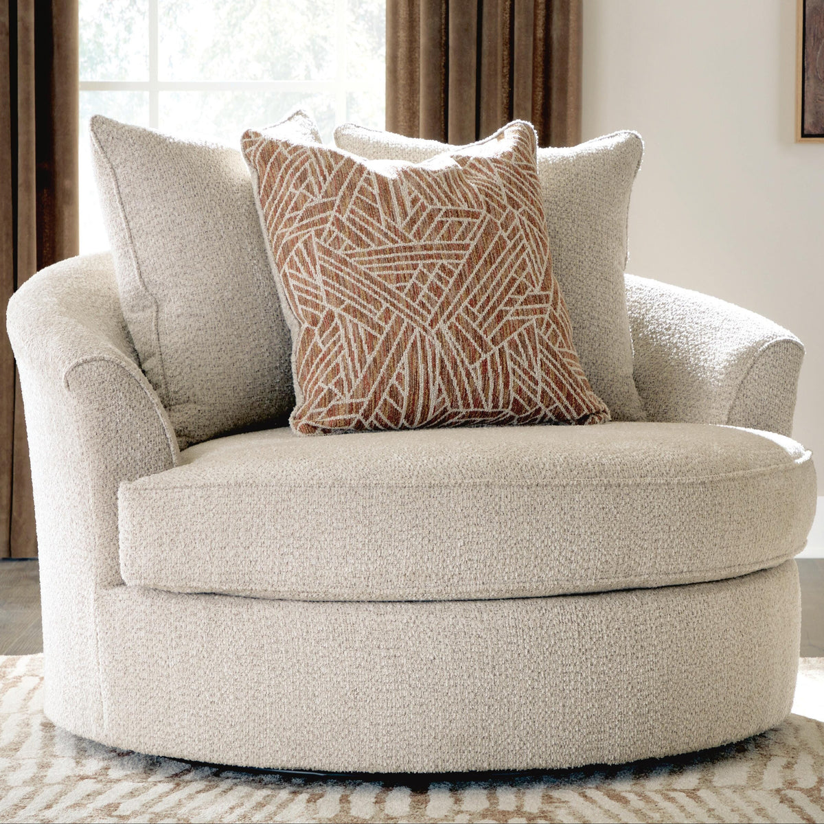 Beige armchair with a patterned pillow in a room setting