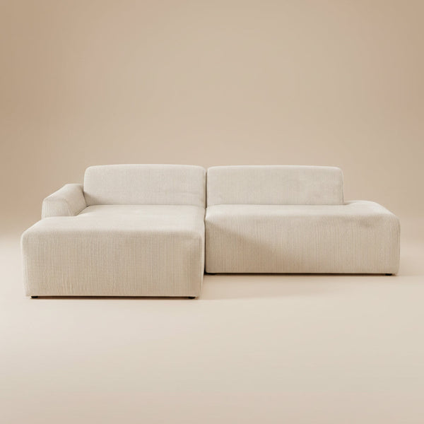 Cream corduroy sectional sofa with left-facing chaise, front view on a plain beige studio backdrop