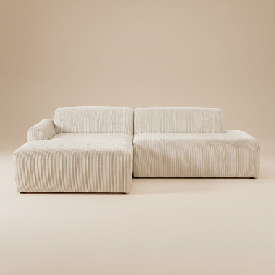 Cream corduroy sectional sofa with left-facing chaise, front view on a plain beige studio backdrop