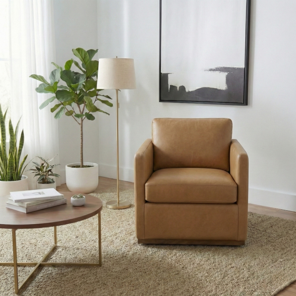 Tan leather lounge chair in a bright living room with fiddle leaf fig, floor lamp and wall art